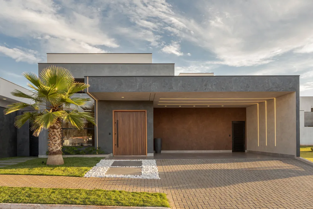 Fachada de casa térrea com porta de madeira e jardim
