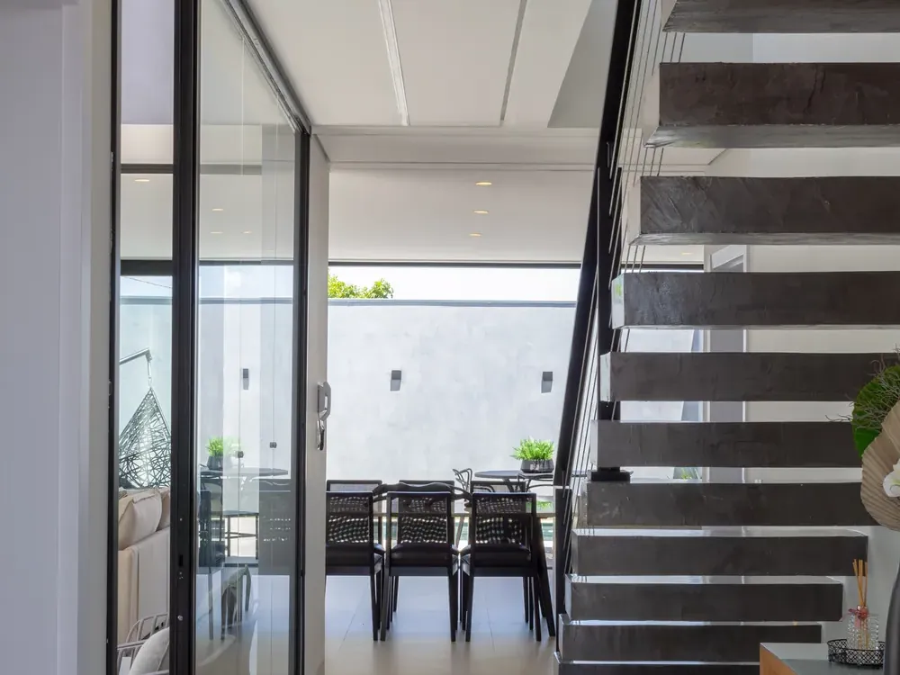 Escada com degraus em balanço e sala de jantar ao fundo